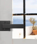 Matte Black Square Dummy Door Lever on a white French door with sea view. Part of 4 pack for French doors and closet hardware. No turning screws visible.