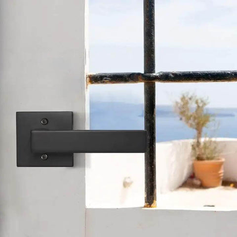 Matte Black Square Dummy Door Lever on a white French door with sea view. Part of 4 pack for French doors and closet hardware. No turning screws visible.