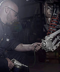 Mechanic using 44mm Wheel Bearing Greaser For Polaris RZR 900 1000 And Pro XP Jansen Motorsports on a UTV suspension