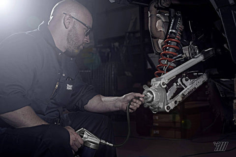 Mechanic using 44mm Wheel Bearing Greaser For Polaris RZR 900 1000 And Pro XP Jansen Motorsports on a UTV suspension