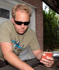 Man wearing UV Protection Safety Goggles With 99 Percent UV Impact Resistant Clear Lenses working on car engine outdoors.