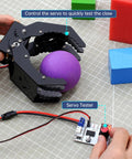 Mechanical Claw Gripper For Robotic Arm DIY Kit With Servo And Tester High Torque Claw Gripper holding purple ball on grid surface