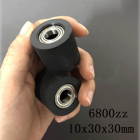 Hand holding two black rubber 6800zz bearings, size 10x30x30mm, for mechanical systems and automation.