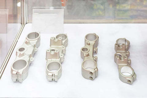 Metal components displayed under glass showcasing aluminum oxide blasted finish