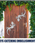 Metal gecko sculptures on wooden door with greenery, related to Beginner Friendly Gecko Welding Kit For Tig Mig Arc Gas Practice.