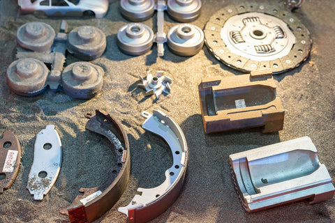 Various metal parts on sandy surface used with 60 Grit Aluminum Oxide Sand Blasting Abrasive Media 8 Pound Bag.