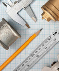 Stainless Steel Ruler Metal Straight Edge 6 Inch Ruler Set 12 Pack Durable Non Bendable Rust Resistant next to tools on grid paper