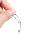 Hand holding a metal safety pin from the Bulk 1000-Piece 1.1-Inch Clips Tool Kit With Assorted Decorative Pins For Sewing And Crafting.