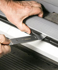 Person using Compact Double End Metal Skin Wedge Prybar Tool By ARES for car panel removal, ultra thin 23 gauge ends visible.