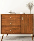 Wooden dresser featuring 3 drawers and a cabinet door, decorated with minimalist items on top in a modern interior setting.