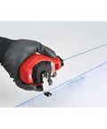 Hand using Milwaukee Chalk Line Reel Set F with 100 ft blue line for marking on surface, showing precise layout application.