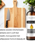 Food Grade Mineral Oil 90 Viscosity NF USP Grade For Cutting Boards Countertops Butcher Blocks Stainless Steel Knives Tools Machines And Equipment 64 Fl Oz Made In The USA Velona bottle next to a cutting board and knife