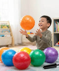 Child playing with Mini Knobby Balls - (Pack of 12) Bulk 5 Inch Sensory Balls and Spiky Massage Stress Balls with Pump in bright colors.