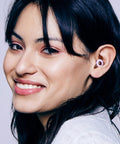 Woman wearing ultra comfortable, reusable ear plugs engineered for sleep, study, travel and quiet moments, M size visible.