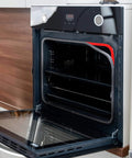 Open modern kitchen oven showing interior shelves and digital controls