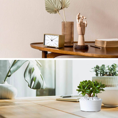 Modern wooden table with clock, books, decorative hand, and plants in bright home setting.