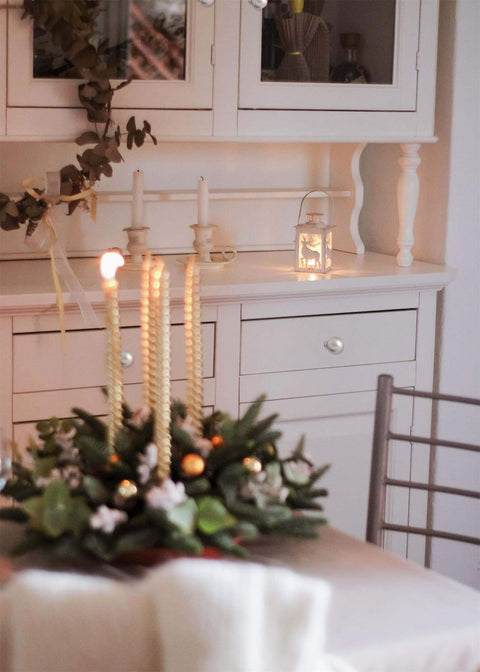 Cozy dining room with festive candle centerpiece and white cabinet backdrop