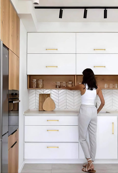 Woman reaching for cabinet with Brushed Gold Cabinet Pulls 5 Inch 128mm Pack Of 10 Kitchen Cabinet Handles in modern kitchen