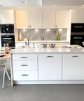 Modern kitchen with white cabinets fitted with Two Pack Knurled Aluminum Cabinet Handles With Gold And Black Oxidation Finish