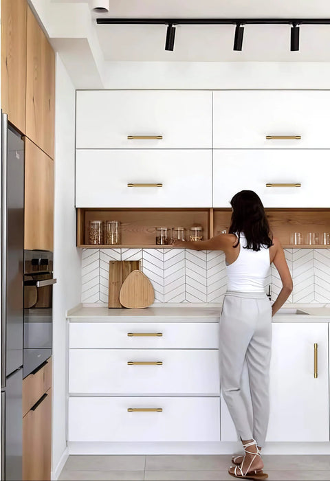 Woman installing 10 Pack Champagne Bronze Knurled Cabinet Pulls, 5 Inch 128mm, on modern white kitchen drawers and cabinets.