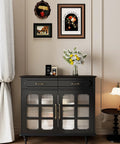 Black cabinet with glass doors and bronze handles, decorated with flowers, in a classic-themed room with framed art on the wall.