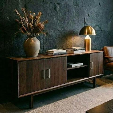Wooden sideboard with brushed nickel cabinet handles, featuring books and a lamp, in a stylish living room setting.