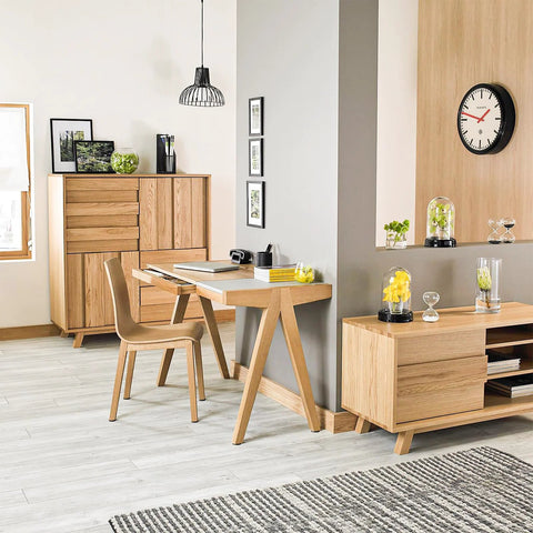 Modern living room with wooden furniture and decorations, featuring a chair, desk, cabinet, and wall art in a minimalist style.