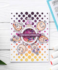 Handmade card with colorful monsters, circular sequin embellishment, and 'I was such a monster' text, on a white wooden background.