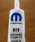 Tube of Mopar RTV Caoutchouc Silicone Sealer for transmissions, featuring branding and nozzle for application