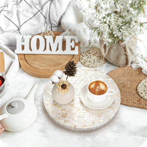 12 inch mother of pearl lazy susan turntable with marble pattern used as a decorative tray for coffee and flowers on a tabletop.