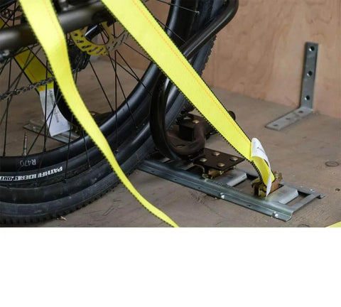 7 Inch Steel Motorcycle Wheel Chock For E Track And X Track System Powder Coated Black Fits Front Tires Up To 7 Inches Wide And 12 Inch Depth Ideal For Trailer Use 2 Pack By Mytee Products installed in trailer with yellow straps securing bike wheel.