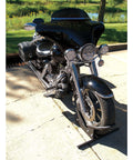 Deluxe Motorcycle Wheel Chock And Tie-Down Kit Extreme Max 5600.3204 holding a motorcycle, outdoor view