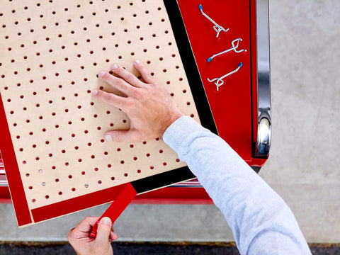 Person using Extreme Double Sided Mounting Tape 414H 1 Inch By 60 Inch Weather Resistant Heavy Duty Adhesive Tape on pegboard.
