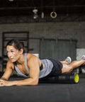 Woman using Patented Multi Density Foam Roller For Deep Tissue Massage And Muscle Recovery Relieves Pain And Tightness Improves Mobility, in gym.