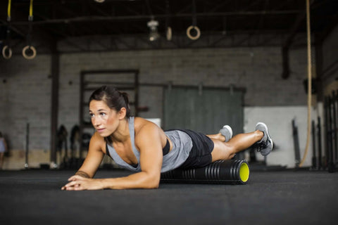 Woman using Patented Multi Density Foam Roller For Deep Tissue Massage And Muscle Recovery Relieves Pain And Tightness Improves Mobility, in gym.