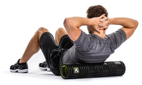 Person using a 26-inch black patented multi-density foam roller for deep tissue massage and muscle recovery, relieves pain and tightness.
