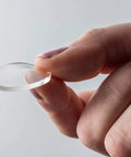 Person holding clear 1-inch circle of Nano Grab Technology Double Sided Gel Tape For Clear Mounts And Quick Fixes, Indoor Outdoor Friendly.