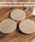 Three natural travertine round trays on wooden table, showcasing unique stone patterns, part of the Natural Travertine Lazy Susan Turntable Organizer set.