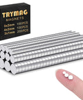 Image of Rare Earth Neodymium Magnets 400 Pcs Set In 3 Sizes For Crafts DIY Fridges Whiteboards Cabinets Nickel Finish showing stacked magnets and size comparison on a fingertip.