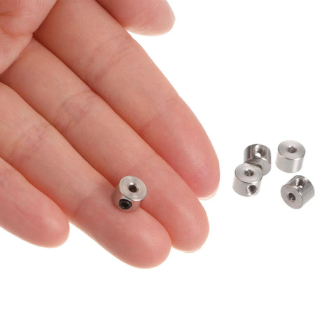Close-up of fingers holding a 10 Pack Set Screw Shaft Collar with Two Point Zero Five Millimeter Bore, nickel-plated carbon steel.