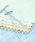 2 Inch T Pins Set Of 100 Nickel Plated Steel Pins With 14 Mm Head on pastel fabric, ideal for crafting and sewing