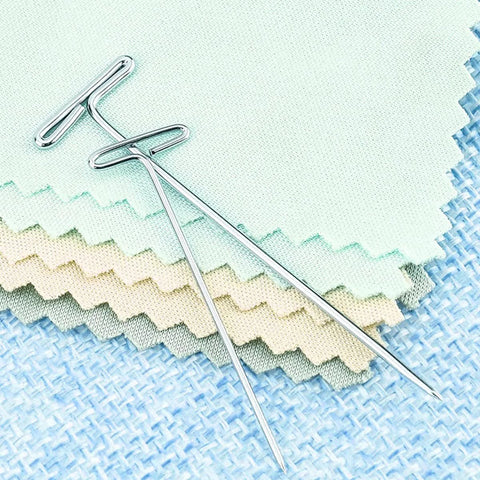 2 Inch T Pins Set Of 100 Nickel Plated Steel Pins With 14 Mm Head on pastel fabric, ideal for crafting and sewing