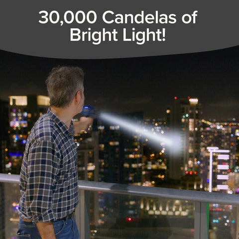 Man using As Seen On TV Mega Bright Rechargeable Spotlight With 10 Modes And Turbo Boost Up To 100 Percent overlooking cityscape at night.