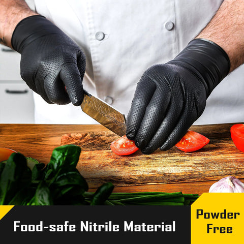 Chef wearing 8 Mil Nitrile Gloves With Diamond Grip For Mechanic Work And Cleaning 100 Ct, slicing tomatoes on cutting board.