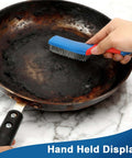 Scrubbing rust off a pan using a 4-Pack Heavy Duty Wire Brush and Scraper Set, focusing on the stainless steel scratch brush with a non-slip handle.