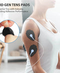 Person using Unit Electrode Pads NURSAL 20 Pack 3.5mm Snap EMS Replacement Pads for Electrotherapy on arm, close-up view.