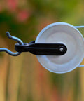 Close-up of mounted 2 PCS Nylon Clothesline Pulley,2-1/2-inch Diameter Nylon Pulley installed on outdoor rope line.