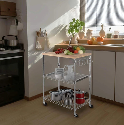 Heavy Duty 3 Tier Rolling Kitchen Cart Workhorse With Oak Wood Top And Drawer Slider Chrome Finish Four Wheels Hooks For Utensils 300 Lb Total Capacity Multi Function Kitchen Island Cart For Cooks And Caterers Finnhomy shown in a kitchen setting with utensils.
