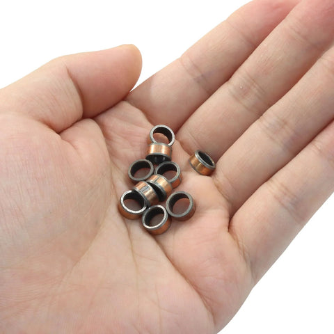 Hand holding Oil Free Sleeve Bearings 10 Pcs 6mm Bore 8mm OD 4mm Length for engineering and automotive use, bronze coating.