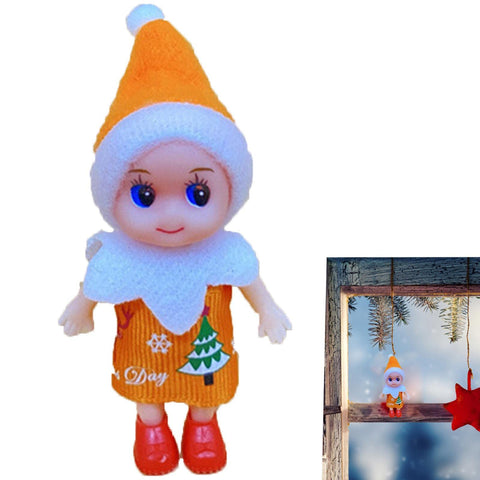 Festive elf doll in orange and white outfit with Christmas tree design and red shoes, next to window display with holiday decor.